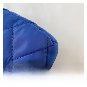 Gros plan sur le tissu en nylon matelassé bleu roi avec un motif de losanges sur le sac