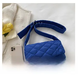 Gros plan du sac bandoulière en nylon matelassé bleu roi avec large sangle réglable