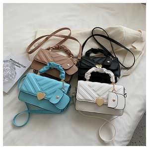 Detail of quilted PU leather handbag with heart buckle and pleated handle in four colors