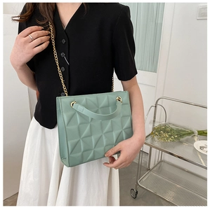 Gros plan sur le sac fourre-tout vert menthe avec chaîne dorée et motifs losanges