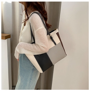 Close-up of color-block large tote bag showing leather texture and adjustable strap detail