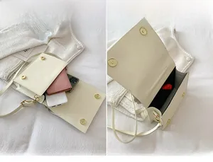 Detail view of the cream leather crossbody bag interior showing spacious main compartment