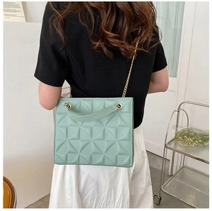 Détail du sac cabas matelassé vert menthe avec bandoulière en chaîne dorée