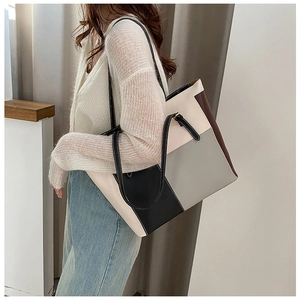 Close-up of stylish color-block PU leather tote bag with patchwork design and slim straps