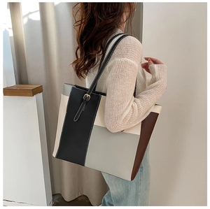 Close-up of color-block tote bag with adjustable gold buckle on the shoulder strap