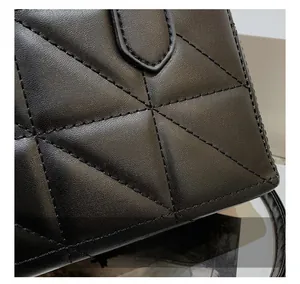 Close-up of black quilted leather texture with precise triangle stitching details