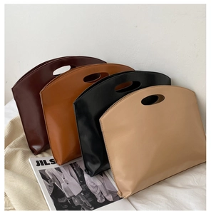 Flat trapezoid tote bags in deep brown, caramel, black and beige on soft bedding