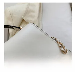 Close-up of precise stitching and black oil edge on a white faux leather handbag