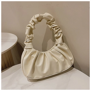 Nahaufnahme einer beigen Cloud-Handtasche mit weichem Raffgriff und matter Textur