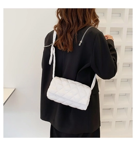 Vue détaillée du dos d'un sac bandoulière blanc matelassé avec motif à losanges et sangle