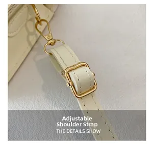 Detail view of adjustable cream PU leather shoulder strap with gold metal buckle and clasp