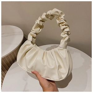 Detail der cremeweißen Falten-Cloud-Tasche mit Fokus auf Grifftextur und weichem Leder