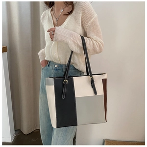 Detail of color-block tote bag with adjustable shoulder strap and precise stitching