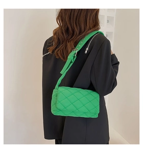 Détail d'un sac bandoulière en nylon matelassé vert vif avec une large sangle réglable