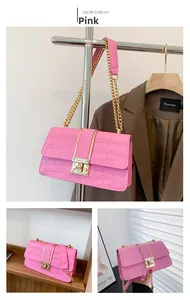 Detailed view of pink shoulder bag with crocodile pattern and golden chain strap