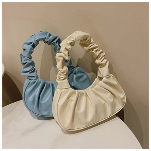 Detailansicht geraffter Cloud-Taschen in Hellblau und Cremeweiß aus feinem Kunstleder