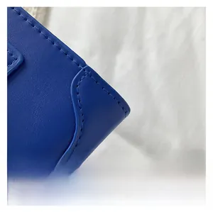 Close-up of royal blue leather handbag with precise stitching on high-quality texture