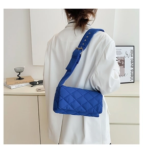 Détail du sac bandoulière bleu en nylon matelassé avec large sangle réglable et œillets
