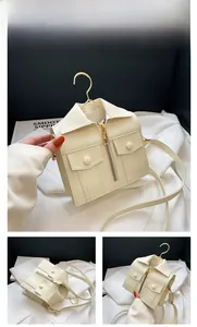 Detail of creative cream white jacket style handbag with metal zippers and gold hooks