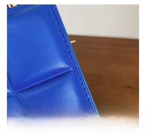 Detail showing the neat stitching and quilted texture on blue leather handbag