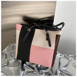 Detail of color-block tote bag showing premium leather texture and white stitching details