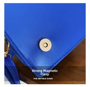 Detail of blue leather handbag showing strong gold magnetic buckle and metal hardware