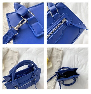 Macro detail of royal blue PU leather handbag showing metal zippers and reinforced stitching