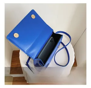 Detail showing bright blue lychee grain leather mini bag with phone interior capacity