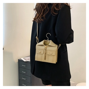 Detail of creative beige jacket-shaped crossbody bag with metal zipper and unique hanger handle