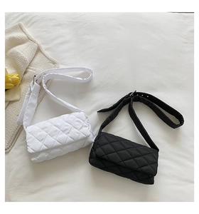 Détail des sacs bandoulière en nylon matelassé noir et blanc avec boucles en métal argenté