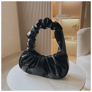 Detail der schwarzen Cloud-Tasche mit Falten-Design auf einem weißen Tisch