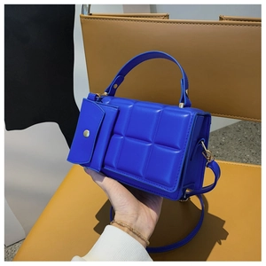 Close-up of royal blue quilted leather handbag with matching small flap pouch and gold hardware