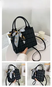 Détail du sac cabas noir à texture gaufrée orné d'un élégant foulard en soie bleu