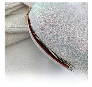 Detail showing colorful sequins on heart-shaped bag with red trim and gold zipper