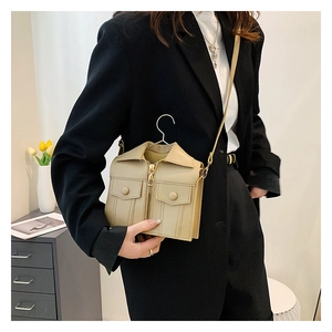 Detail of creative beige leather jacket-shaped crossbody bag with realistic zipper and collar