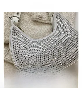 Detail view of crescent shoulder bag with silver rhinestones and adjustable leather strap