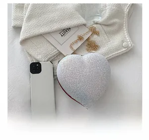 Macro shot of silver sequined heart-shaped mini bag with elegant gold chain strap