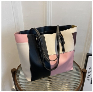 Detailed view of color block tote bag featuring smooth PU leather and precise side stitching