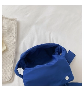 Détail du sac à main matelassé en nylon bleu roi avec fermeture magnétique argentée