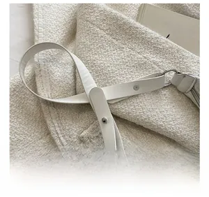 Detail of white leather shoulder strap with silver metal buckle and sparkling rhinestones