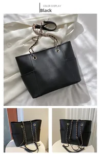 Detail of black tote bag with woven chain strap and premium lychee texture