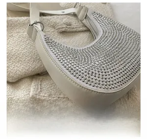 Detail showing precise stitching and silver rhinestones on a white crescent hobo bag