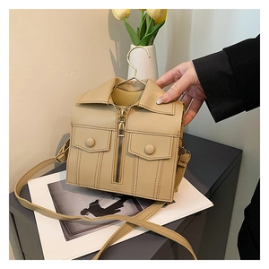 Close-up of creative jacket-shaped crossbody bag with metal zipper and collar detail