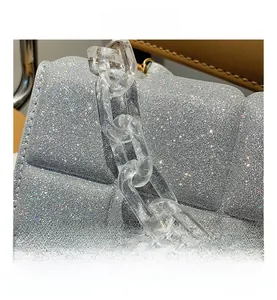 Detail of silver sequined handbag with thick transparent acrylic chain and quilted texture