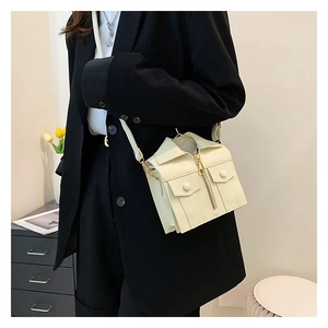 Detail of creative suit-shaped beige crossbody bag worn by model in a modern room