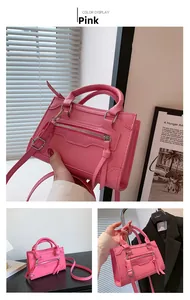 Pink matte leather handbag showing top handles, tassel zipper detail and shoulder strap