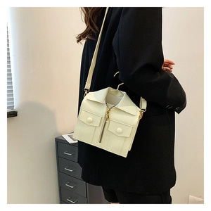 Detail of creative jacket-shaped crossbody bag in cream white with realistic collar and zippers