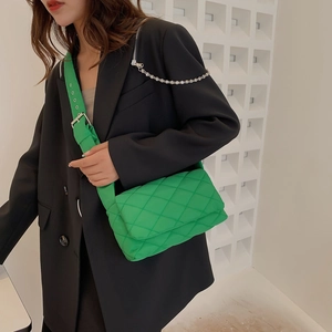 Sac bandoulière vert vif en nylon matelassé avec motif à losanges porté par un mannequin
