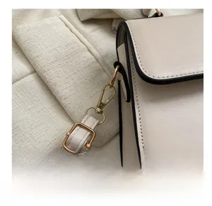 Detailed close-up of cream leather bag with gold hardware hooks and black edge paint