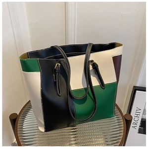 Detail of multi-color block tote bag with geometric leather panels and sturdy handles